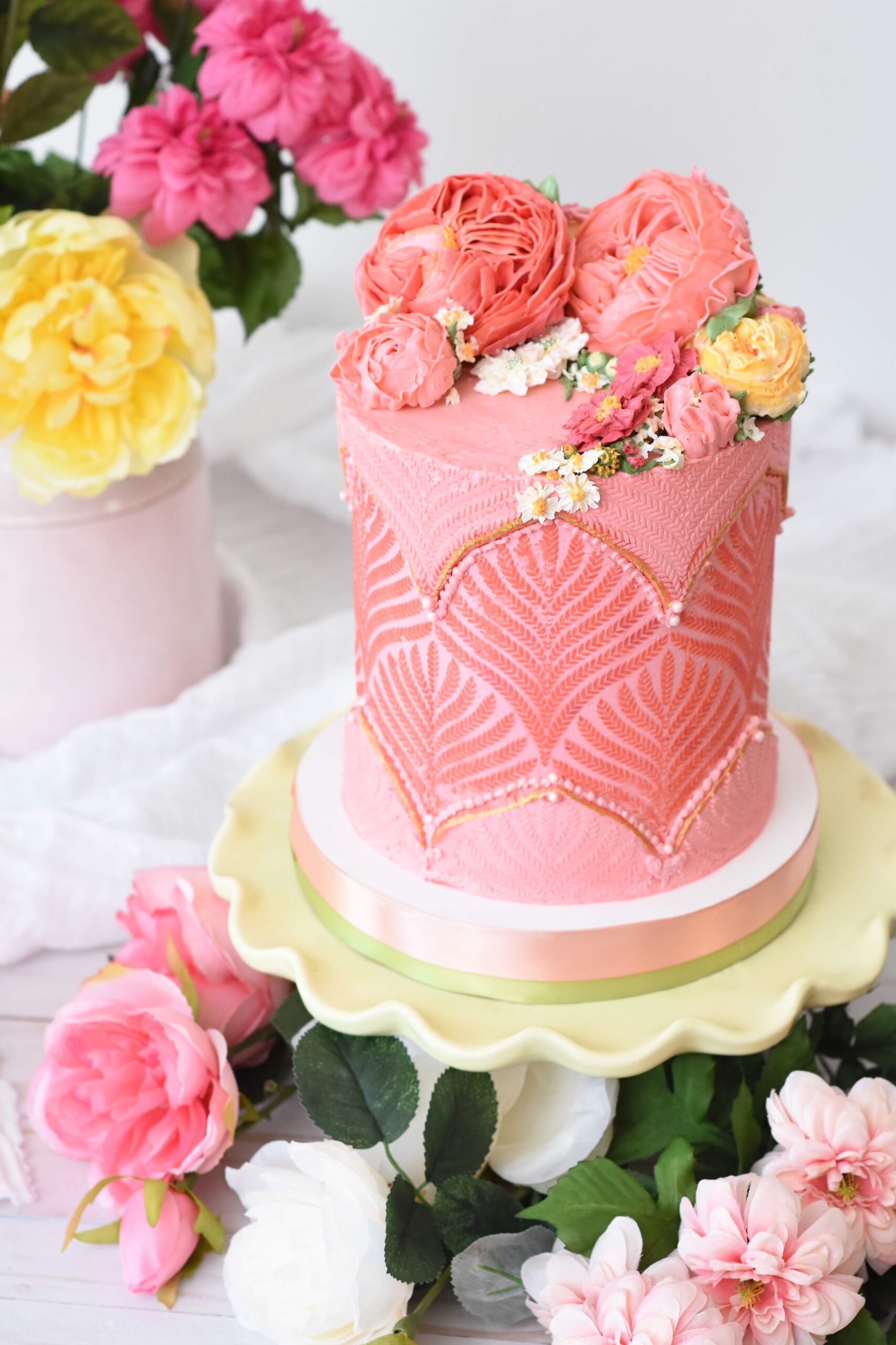 A beautifully decorated flower cake dessert with flowers around and white background